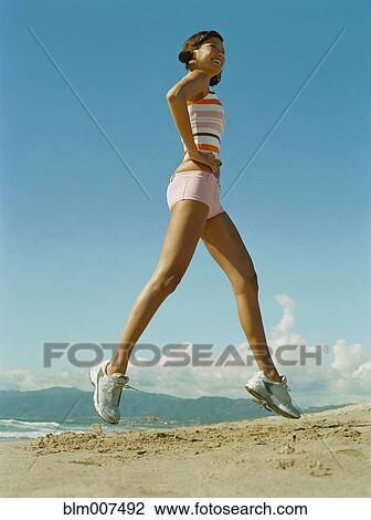 Mixed race woman exercising on beach View Large Photo Image Stock Image - Mixed race woman exercising on beach. Fotosearch