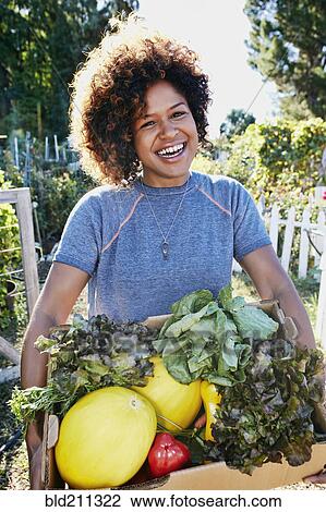 Mixed race woman harvesting vegetables in garden View Large Photo Image Stock Image - Mixed race woman harvesting vegetables in garden. Fotosearch
