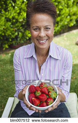 Mixed race woman holding a bowl of strawberries View Large Photo Image Stock Image - Mixed race woman holding a bowl of strawberries. Fotosearch
