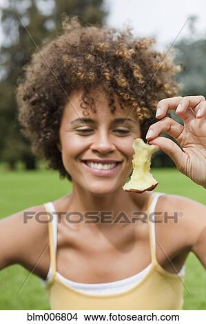 Mixed race woman holding apple core View Large Photo Image Picture - Mixed race woman holding apple core. Fotosearch