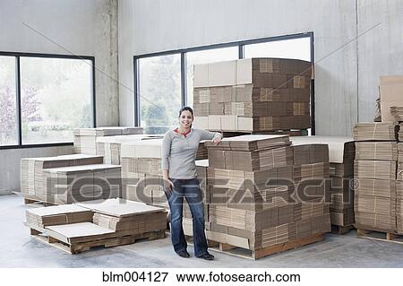 Mixed race woman leaning on flattened boxes in warehouse View Large Photo Image Stock Photo - Mixed race woman leaning on flattened boxes in warehouse. Fotosearch