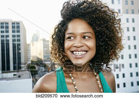 Stock Image - Mixed race woman on urban rooftop. Fotosearch