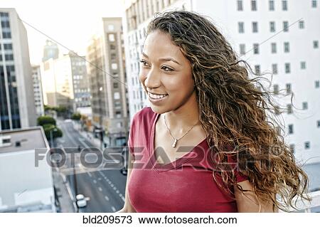 Stock Image - Mixed race woman on urban rooftop. Fotosearch