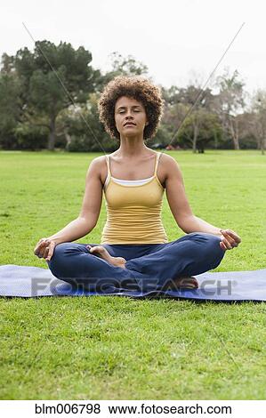 Mixed race woman practicing yoga in park View Large Photo Image Stock Photo - Mixed race woman practicing yoga in park. Fotosearch