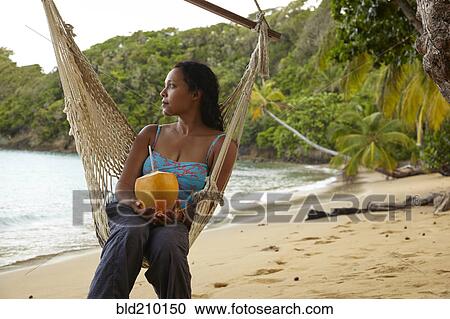 Mixed race woman relaxing in hammock on beach View Large Photo Image Stock Image - Mixed race woman relaxing in hammock on beach. Fotosearch