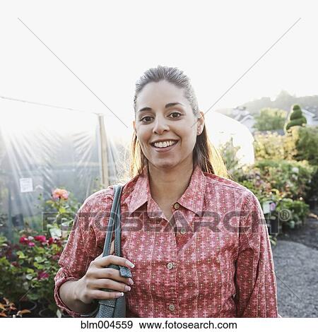 Stock Photo - Mixed race woman shopping in garden nursery. Fotosearch