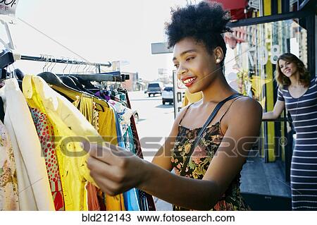 Stock Image - Mixed race woman shopping on city street. Fotosearch
