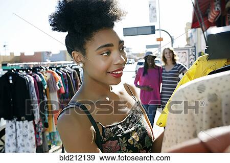 Stock Photo - Mixed race woman shopping on city street. Fotosearch