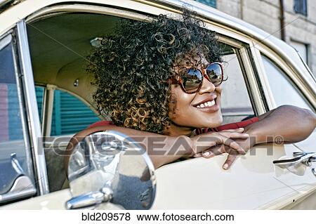 Mixed race woman sitting in vintage car View Large Photo Image Stock Photo - Mixed race woman sitting in vintage car. Fotosearch