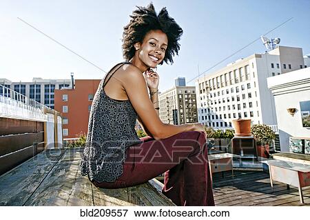 Mixed race woman sitting on urban rooftop View Large Photo Image Stock Photo - Mixed race woman sitting on urban rooftop. Fotosearch