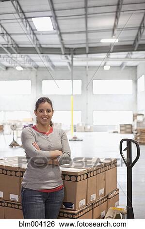 Mixed race woman smiling by pallet of boxes in warehouse View Large Photo Image Stock Photograph - Mixed race woman smiling by pallet of boxes in warehouse. Fotosearch