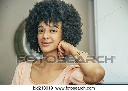 Stock Photo - Mixed race woman smiling indoors. Fotosearch