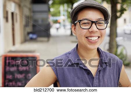 Stock Image - Mixed race woman smiling on city street. Fotosearch