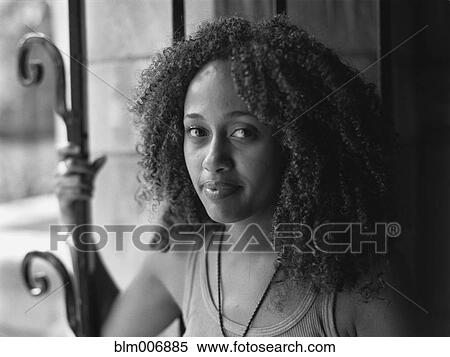 Stock Photography - Mixed race woman standing near window. Fotosearch