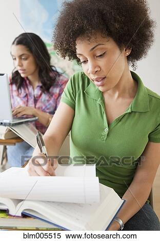 Mixed race woman taking notes in college classroom View Large Photo Image Stock Photography - Mixed race woman taking notes in college classroom. Fotosearch
