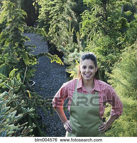 Stock Photograph - Mixed race woman working in garden nursery. Fotosearch
