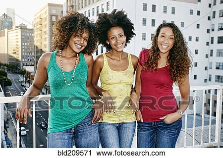 Stock Image - Mixed race women on urban rooftop. Fotosearch