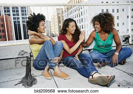 Stock Photo - Mixed race women on urban rooftop. Fotosearch