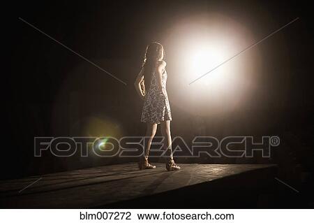 Stock Image - Model in spotlight on fashion runway. Fotosearch