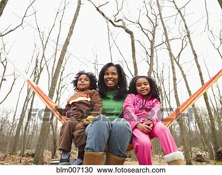 Mother and children sitting in hammock in autumn View Large Photo Image Stock Image - Mother and children sitting in hammock in autumn. Fotosearch
