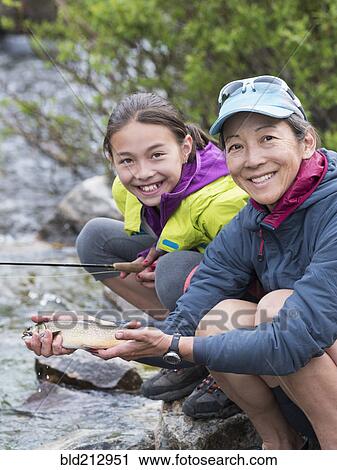 Mother and daughter fishing in river View Large Photo Image Stock Image - Mother and daughter fishing in river. Fotosearch