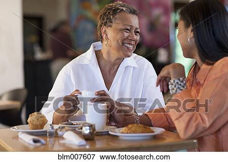 Stock Photo - Mother and daughter having pastry in cafe. Fotosearch