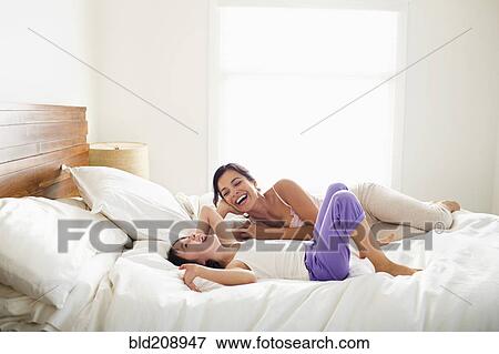 Stock Photo - Mother and daughter laying in bed. Fotosearch