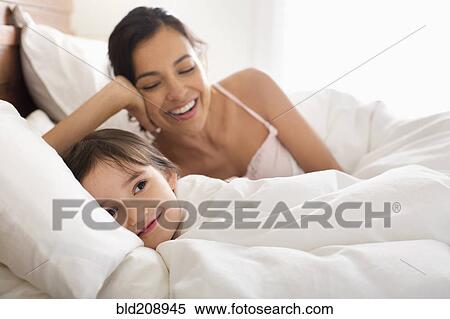Stock Photography - Mother and daughter laying in bed. Fotosearch
