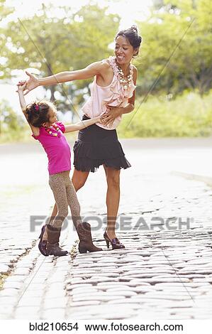 Picture - Mother and daughter posing on city street. Fotosearch