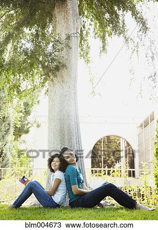 Mother and daughter reading in park View Large Photo Image Stock Image - Mother and daughter reading in park. Fotosearch