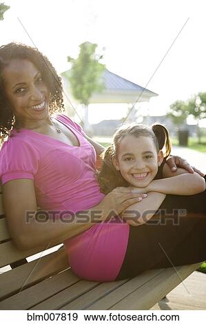Mother and daughter sitting on park bench View Large Photo Image Stock Photo - Mother and daughter sitting on park bench. Fotosearch