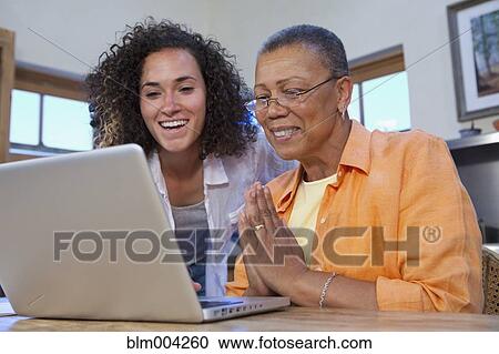 Stock Image - Mother and daughter using laptop. Fotosearch