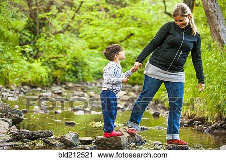 Mother and son exploring rocky creek View Large Photo Image Stock Image - Mother and son exploring rocky creek. Fotosearch