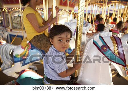 Stock Photo - Mother and son on merry-go-round. Fotosearch