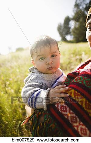 Stock Photo - Mother holding baby in field. Fotosearch
