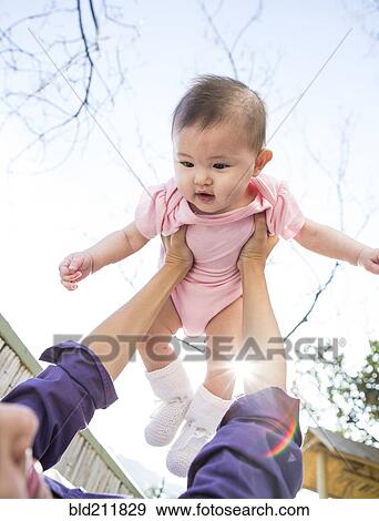 Mother playing with baby girl outdoors View Large Photo Image Stock Photo - Mother playing with baby girl outdoors. Fotosearch