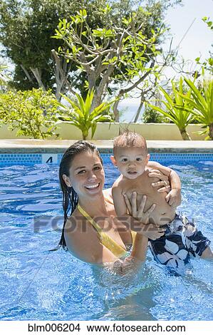 Picture - Mother playing with son in swimming pool. Fotosearch