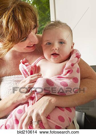 Picture - Mother wrapping baby girl in towel. Fotosearch