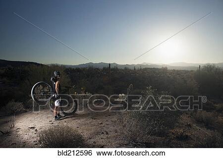 Mountain biker standing in desert View Large Photo Image Stock Photograph - Mountain biker standing in desert. Fotosearch