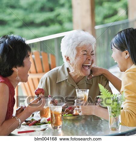 Stock Photo - Multi-generation Japanese women eating and laughing. Fotosearch