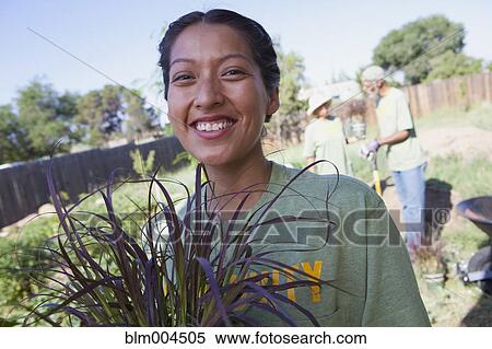 Stock Photography - Native American woman planting community garden. Fotosearch