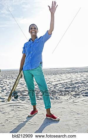 Older Black woman holding skateboard on beach View Large Photo Image Stock Photo - Older Black woman holding skateboard on beach. Fotosearch