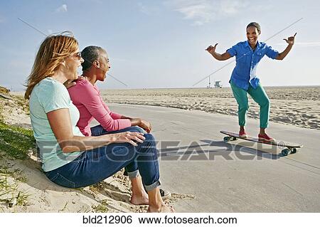 Older Black woman skateboarding by friends on beach View Large Photo Image Stock Photograph - Older Black woman skateboarding by friends on beach. Fotosearch