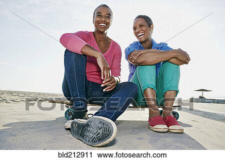 Older Black women sitting on skateboard on beach View Large Photo Image Stock Image - Older Black women sitting on skateboard on beach. Fotosearch