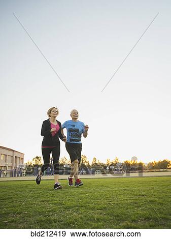 Older couple jogging together in urban park View Large Photo Image Stock Photo - Older couple jogging together in urban park. Fotosearch