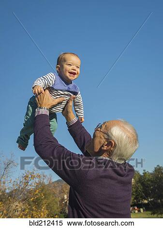 Stock Photography - Older man playing with grandson outdoors. Fotosearch