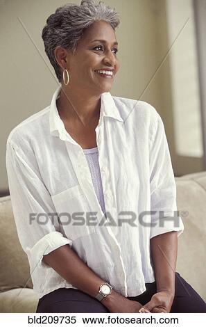 Older woman smiling on sofa View Large Photo Image Stock Photography - Older woman smiling on sofa. Fotosearch