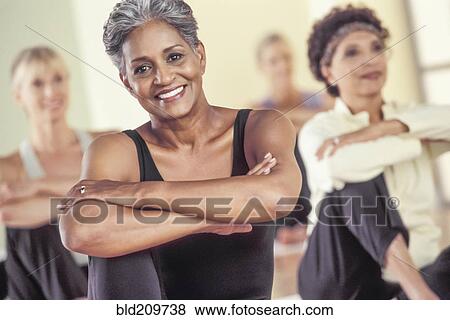 Stock Photo - Older women stretching in exercise class. Fotosearch