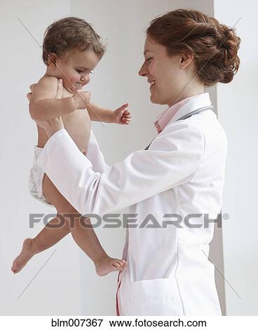 Stock Photo - Pediatrician lifting child. Fotosearch