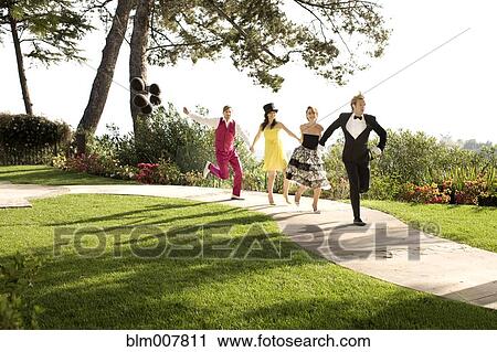 Stock Image - People in elegant clothing running on path in park. Fotosearch
